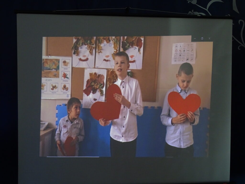 Zdjęcie trojga dzieci, którzy stoją w rzędzie i trzymają serca